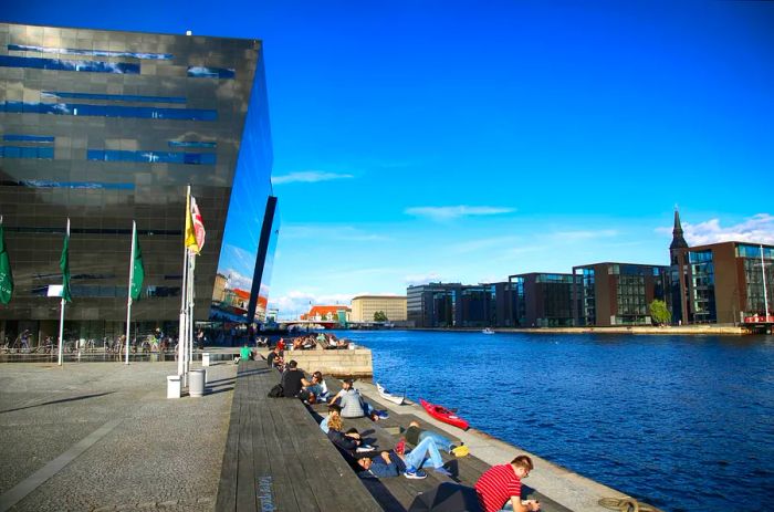 Visitors unwind by the Black Diamond, Denmark's national library.