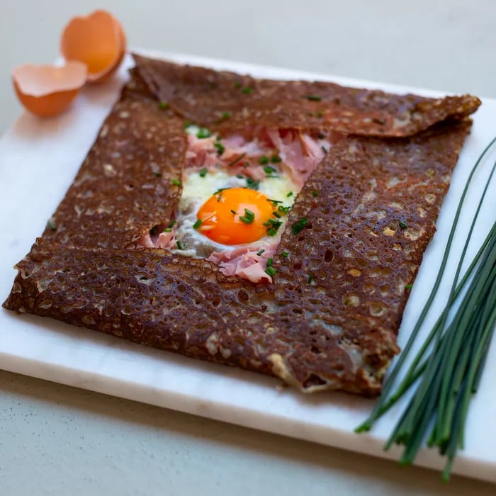 A buckwheat crepe with an egg peeking through the center.