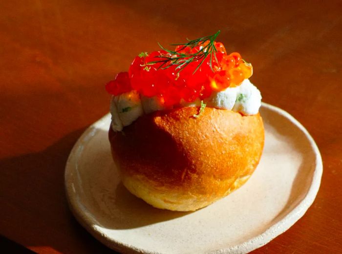 A fluffy maritozzo brimming with ricotta and topped with ikura.