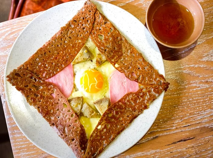 A galette stuffed with a fried egg and meat.