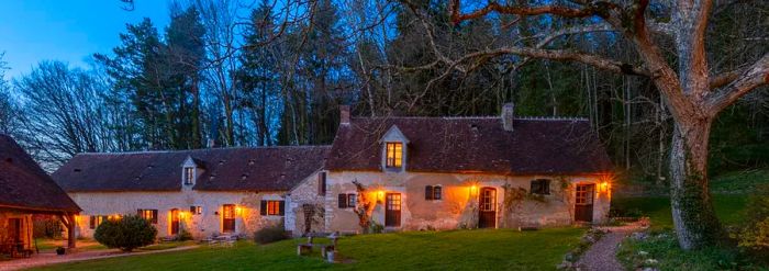 A rustic country inn amidst the woods illuminated in the evening glow.