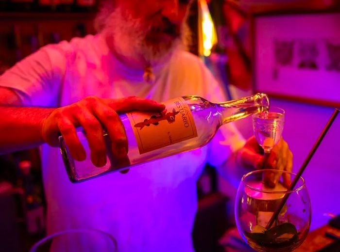 A bartender serves from a signature gin bottle.