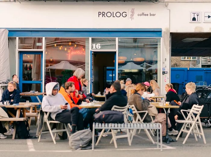 Diners enjoying their meals at outdoor tables of a café.