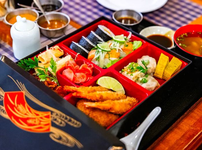 A bento box featuring a variety of maki, tempura, tamagoyaki, and more.