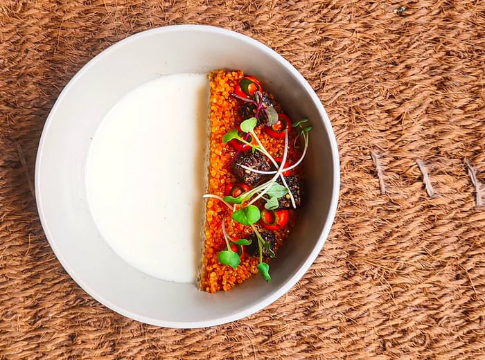 Aerial view of a baked grain dish garnished with herbs and various toppings.