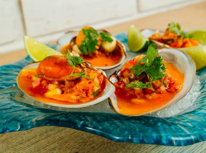 A vibrant orange stew served in clam shells.