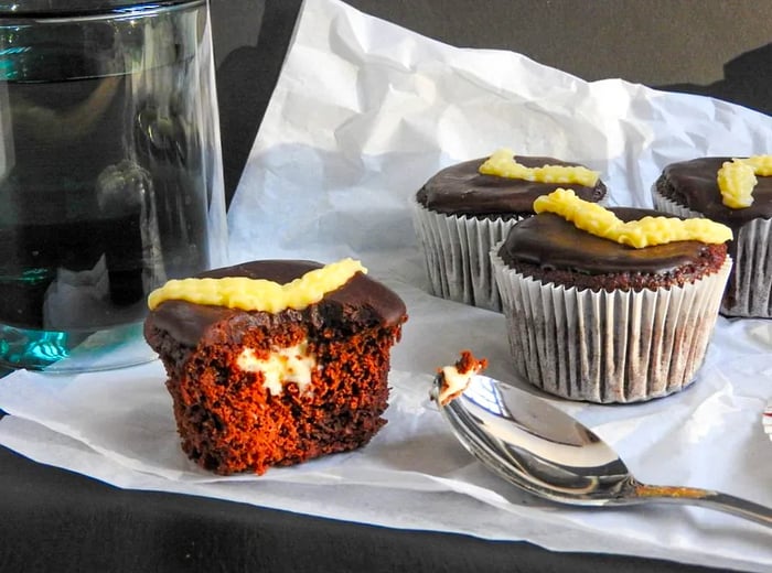 A chocolate cupcake filled with cream and drizzled with icing.