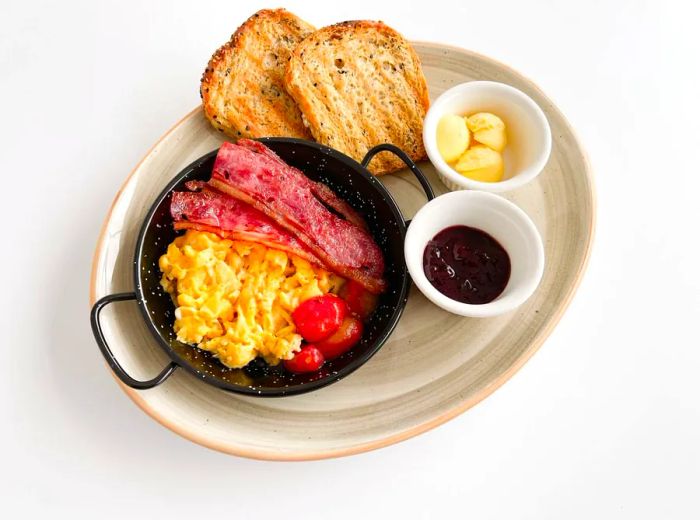 A breakfast spread featuring eggs, bacon, and toast.