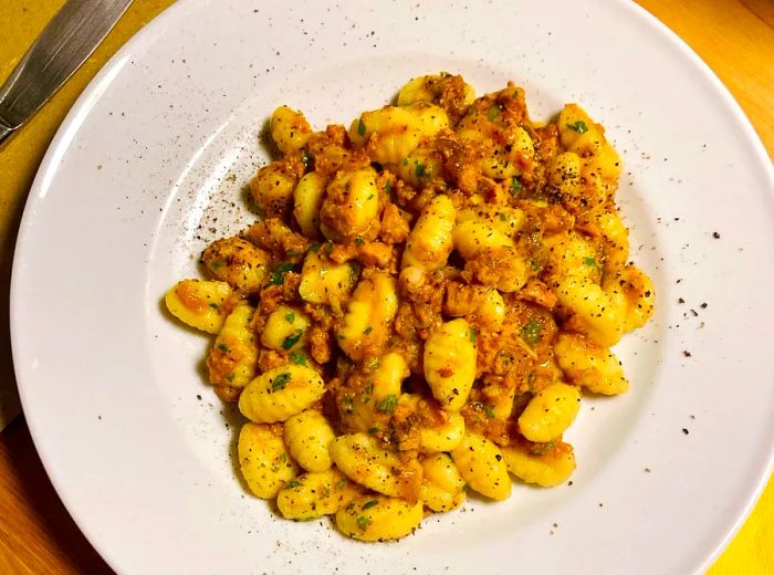 A plate of gnocchetti dressed with meat sauce.