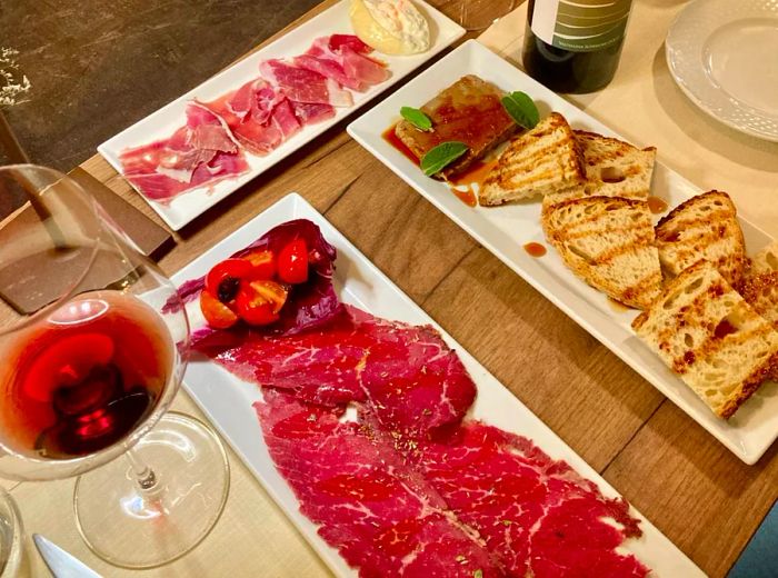 Plates of charcuterie accompanied by wine.