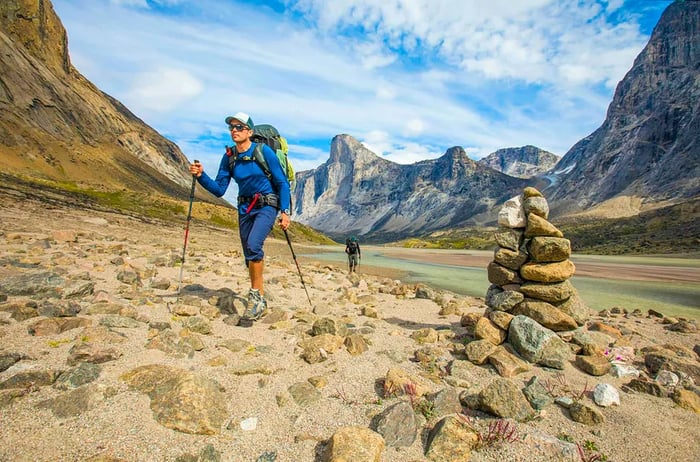 Backpackers pass by a cairn that marks the trail.