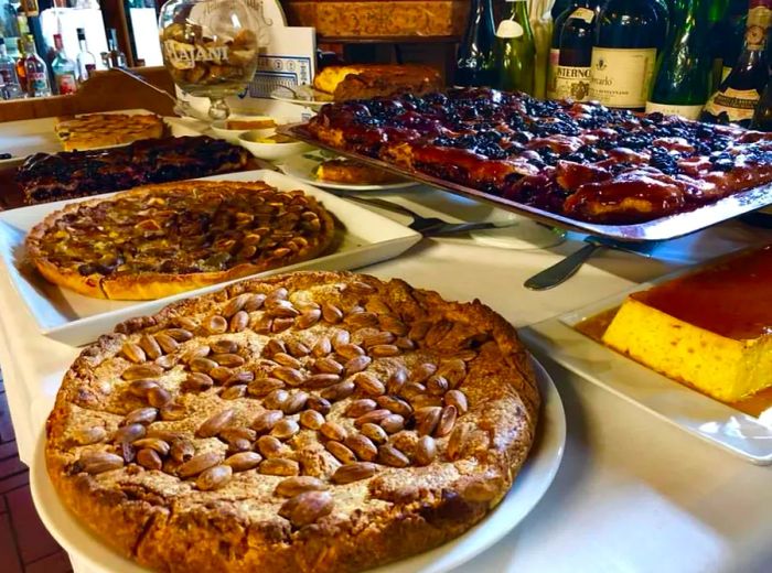 An array of baked goods and topped dishes displayed on a restaurant counter