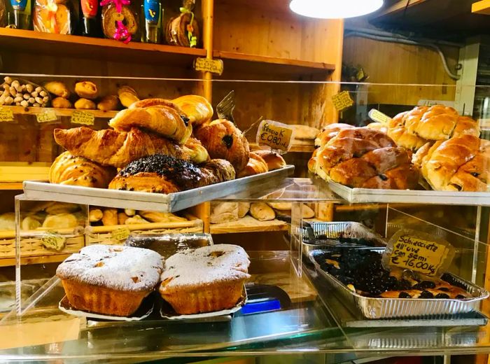 A counter filled with an array of pastries displayed on trays.