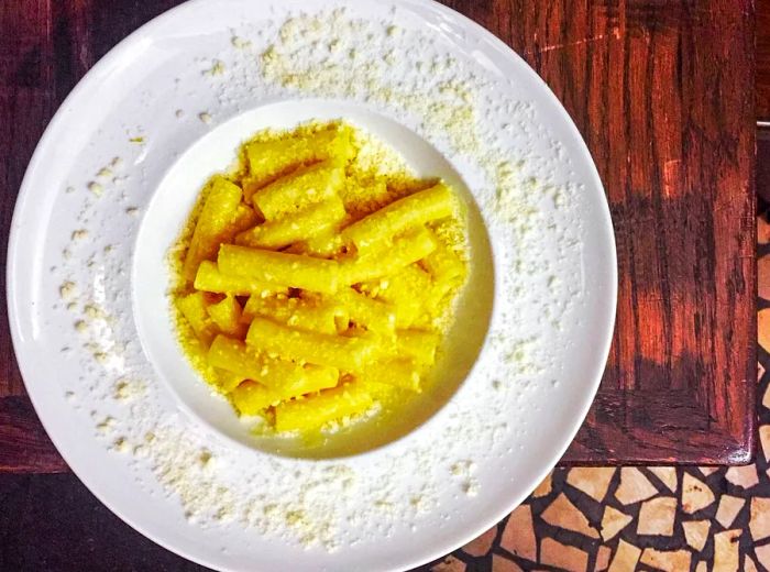 Aerial view of a vibrant yellow plate of pasta.