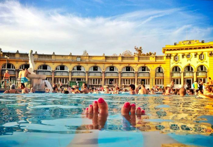 A woman relaxes her feet in the warm waters of Széchenyi Thermal Bath in Budapest