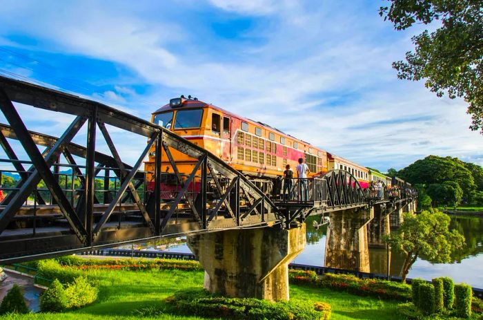 Onlookers watch a train cross the Death Railway bridge in Kanchanaburi, Thailand.