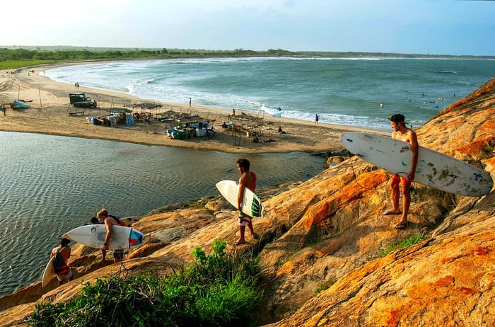 Surfers descend Elephant Rock to hit the waves at a beach in Sri Lanka.