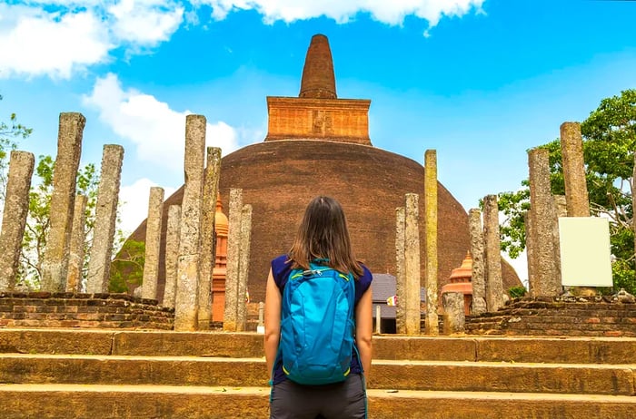 A girl admires the ruins of the Abhayagiri stupa in Anuradhapura, Sri Lanka.