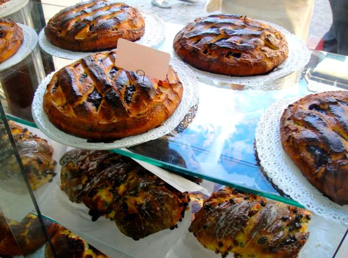 A display case filled with a variety of cakes.