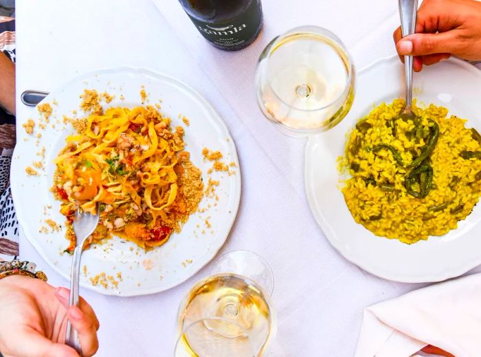 From an overhead view, diners savor two plates of pasta.