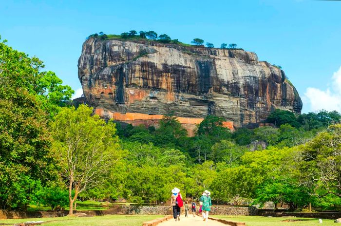 Visitors stroll through gardens leading to the rocky ruins of Sigiriya, Sri Lanka.