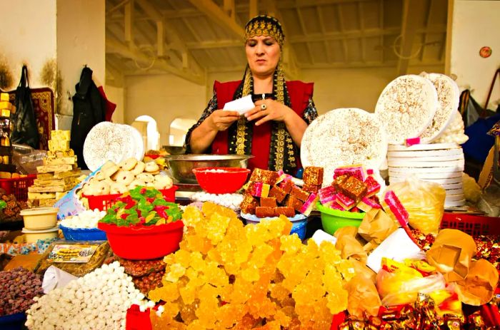 Vendors selling sweets, nuts, and dried fruits at the market in the historic town of Bukhara.