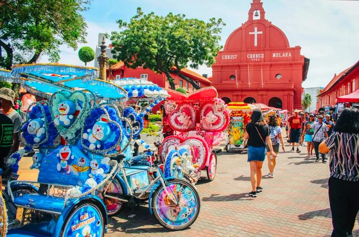 A line of vibrant four-wheeled cycles is parked in a central square, framed by a large red-painted church building.