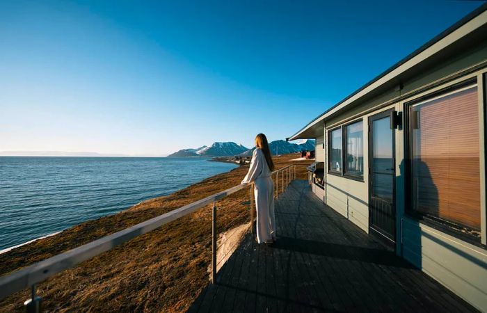 Cecilia reveling in the Midnight Sun just outside her cabin in Svalbard