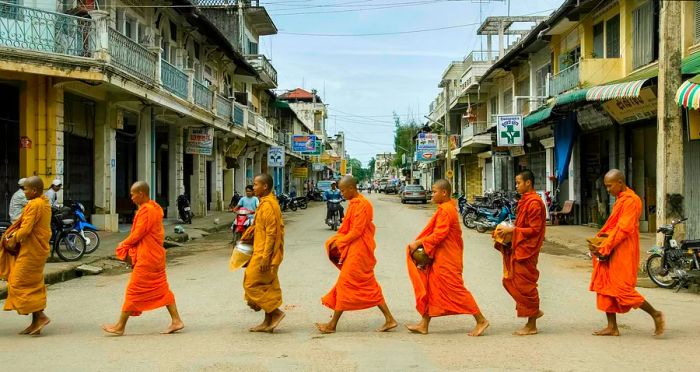 Monks gracefully traverse the urban streets, reminiscent of Luang Prabang.