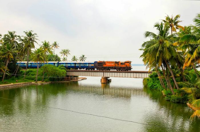 A train travels across a railway bridge in Manroe Island on October 15, 2017, in Kollam, Kerala, India.