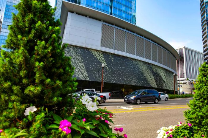 Public art display in Rosslyn, with colorful flowers in the foreground and cars passing by