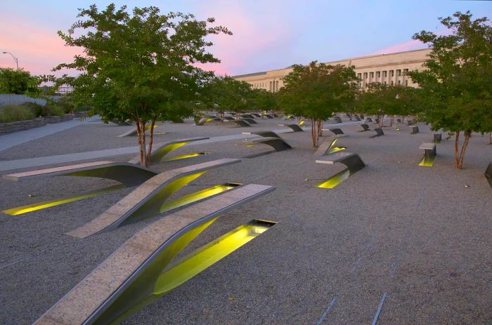 The Pentagon Memorial showcases 184 empty benches illuminated at sunset, serving as a tribute to those lost during the September 11, 2001 attacks in Arlington, VA.