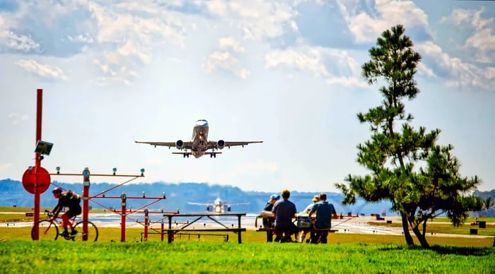 Picnickers at Gravelly Point Park enjoying their lunch while planes soar overhead from Reagan National Airport.