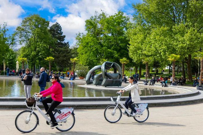 People enjoy biking and unwinding in the park at Karlsplatz, right in front of St. Charles Church (Karlskirche).