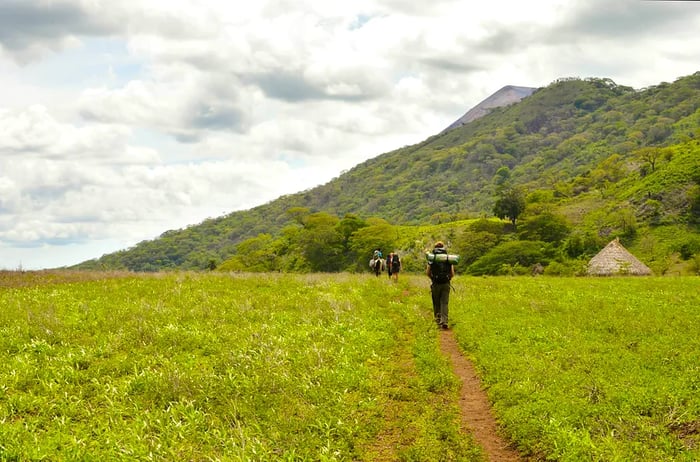 A group of hikers treks through the fields, preparing to climb the very active Telica volcano in San Jacinto, Leon, Nicaragua. Central America