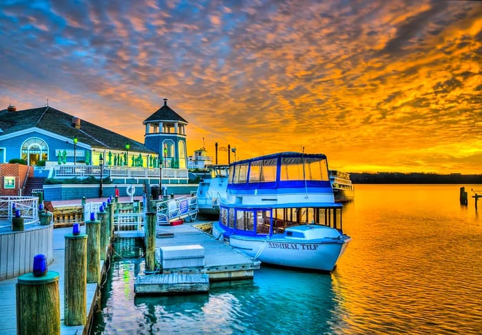 A boat glides along the dock at the Old Town waterfront during sunset, Alexandria, VA