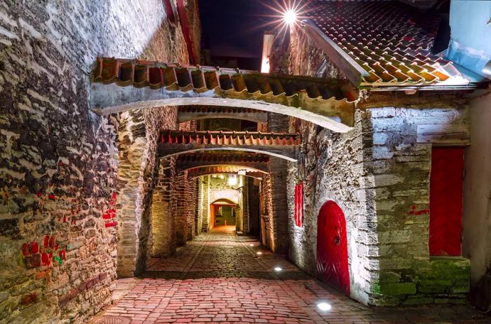 The medieval St. Catherine's Passage, or Katariina kaik, is a charming, somewhat concealed walkway in the Old Town, particularly enchanting at night in Tallinn, Estonia.