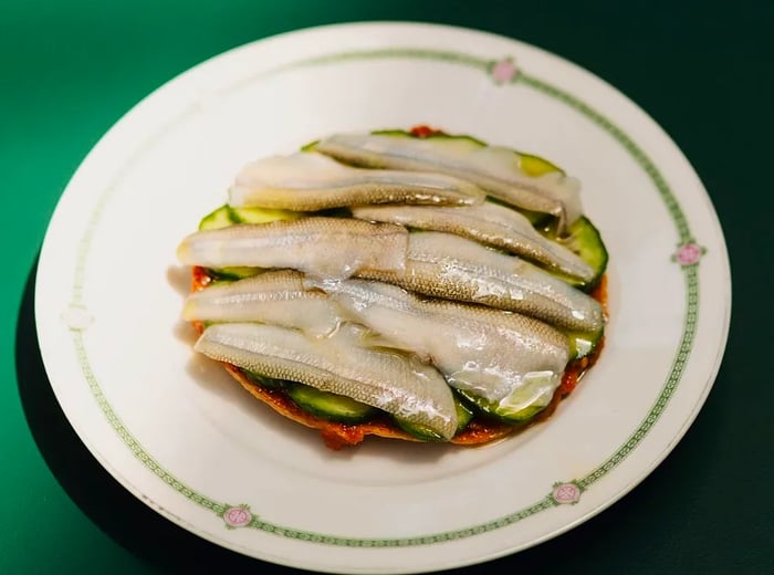 Fish slices atop an avocado-laden tostada.