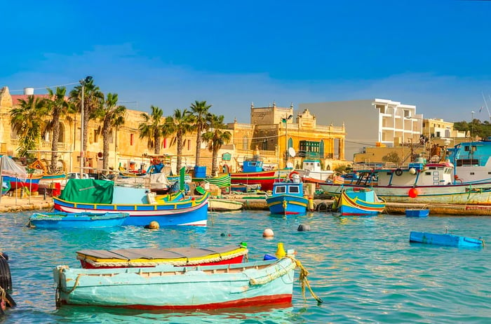 Vibrantly colored luzzu boats in the harbor of Marsaxlokk, Malta.