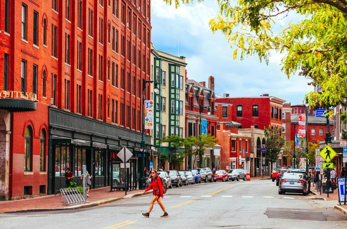 A woman crosses the street in downtown Portland, Maine, USA