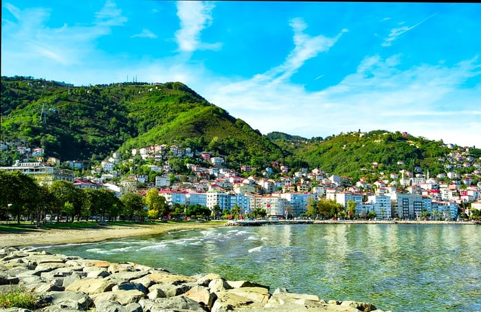 The rocky coastline of a seaside town, with buildings nestled against the steep hillside.