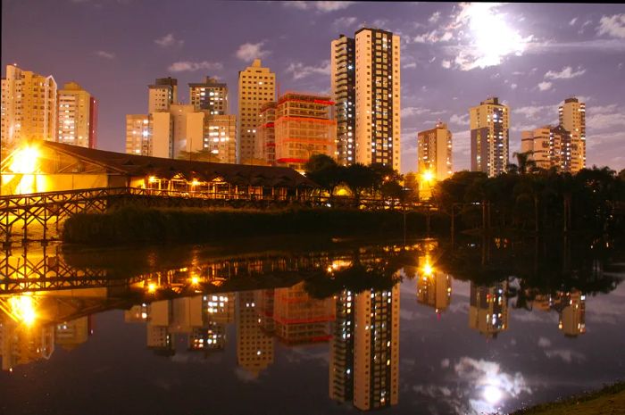 A nighttime view of the skyline across the lake at the botanical garden in Curitiba, Paraná, Brazil