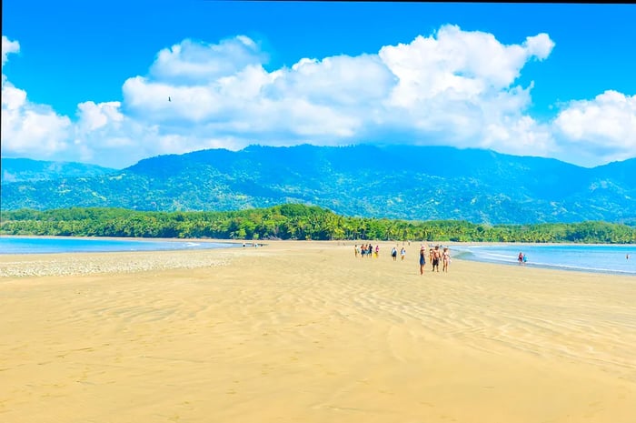 Visitors stroll along the vast stretch of sand at Punta Uvita.