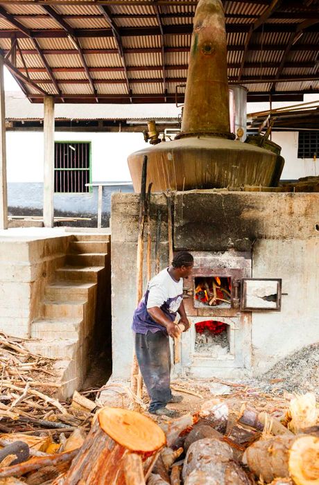 A man tending the fire at River Antoine Rum Distillery in Grenada