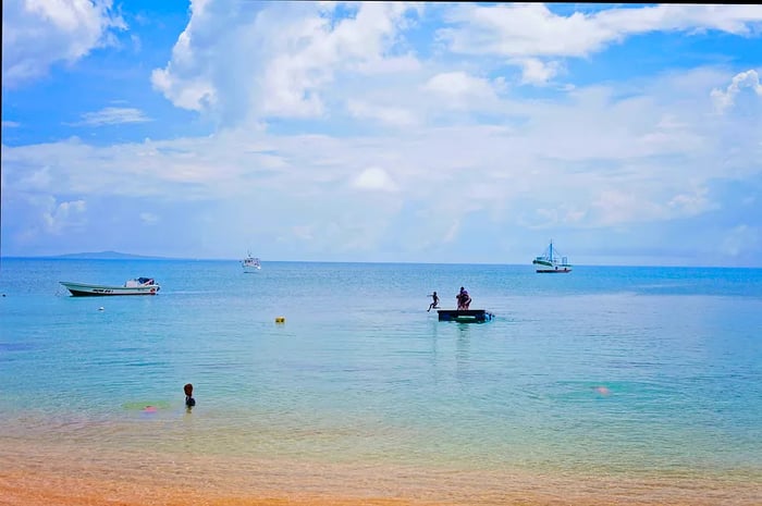 Gazing out at the clear tropical waters where people and boats relax and play, you can see Big Corn Island on the horizon.