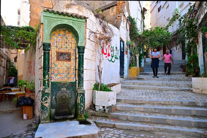 Men walking through a narrow alley in the historic Casbah of Algiers, Algeria