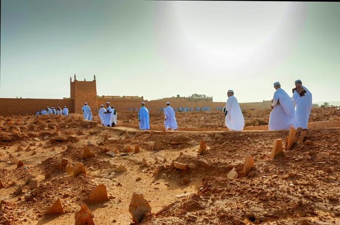 M’zab individuals in white robes approach a mosque in El Guerrara, Ghardaïa, Algeria