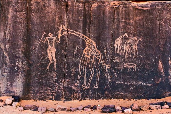 Ancient rock engraving featuring a human and a giraffe, Tassili n’Ajjer National Park, Algeria