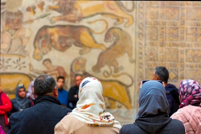 A view of tourists admiring the ancient mosaics at Djemila, Algeria