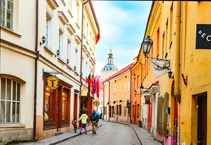 Tourists stroll down a narrow street in Vilnius's Old Town, Lithuania